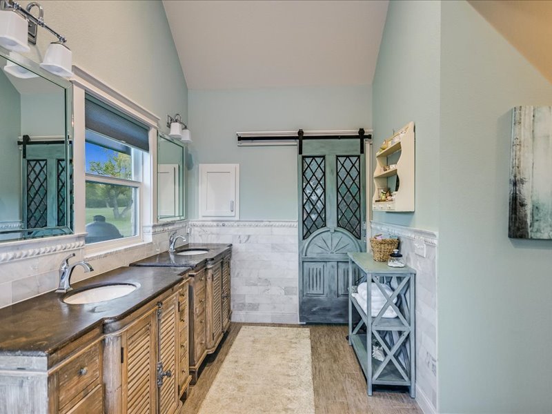 14036 Timberline Trail Austin, TX 78737 - Photo 15 of 40 Main bathroom has granite countertops, double vanity sinks, and tile floors. Lots of light from window areas.