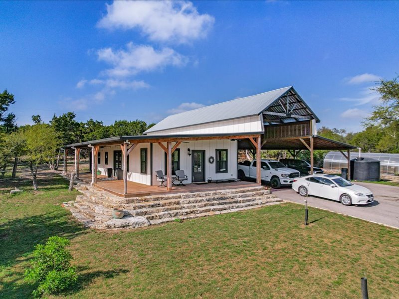 14036 Timberline Trail Austin, TX 78737 - Photo 22 of 40 View of front of guest house featuring covered porch, a yard, Adjacent to a covered carport with parking for vehicles, equipment and a large RV section with full hookup.