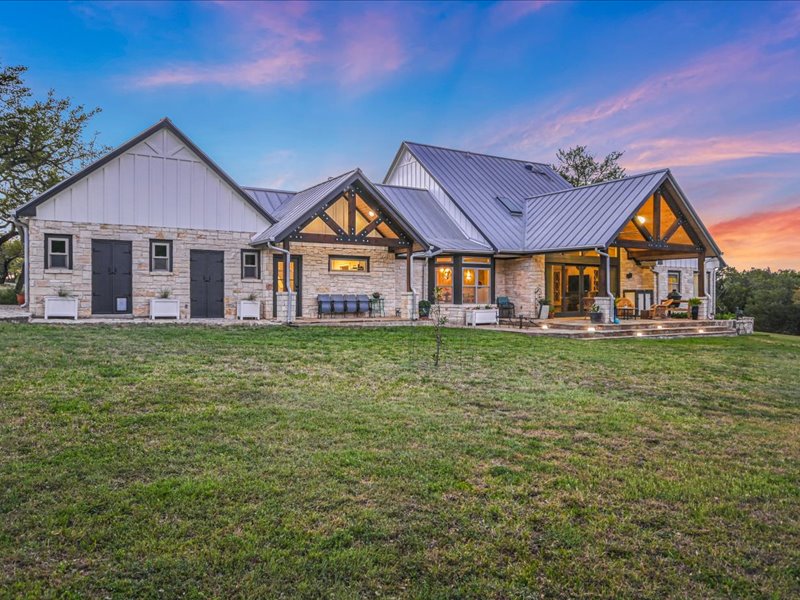 14036 Timberline Trail Austin, TX 78737 - Photo 4 of 40 View of front of home featuring a front yard, a patio, stone siding, board and batten siding, and a standing seam roof
