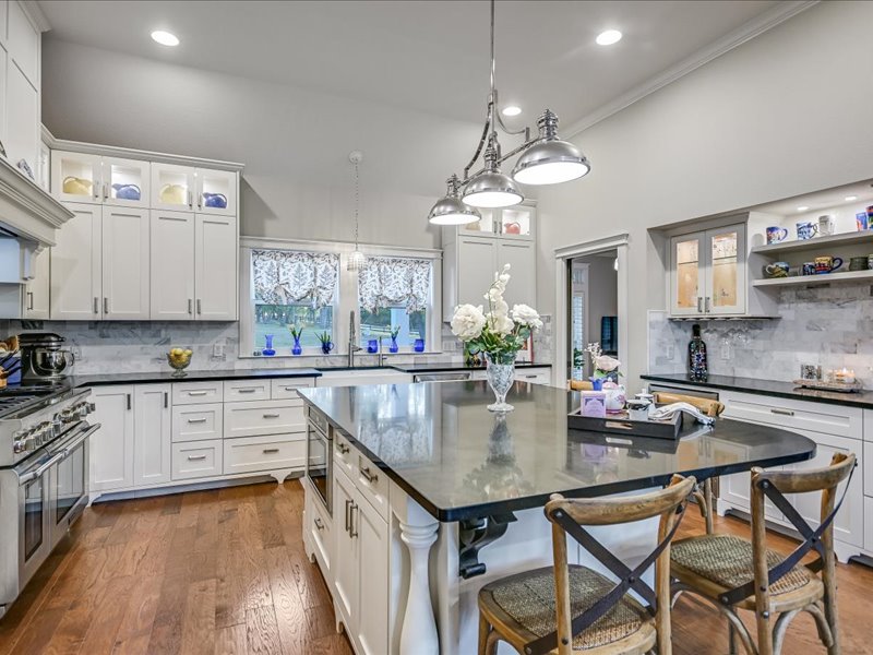 14036 Timberline Trail Austin, TX 78737 - Photo 6 of 40 Kitchen featuring glass fronted cabinets, backsplash, a kitchen breakfast bar, a kitchen island, and dark wood finished floors