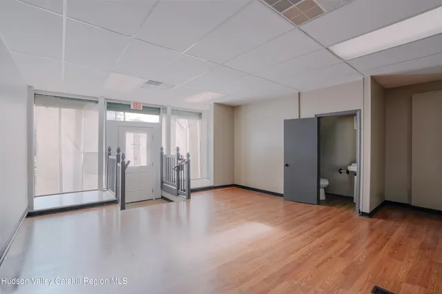 a view of a livingroom with wooden floor and a refrigerator