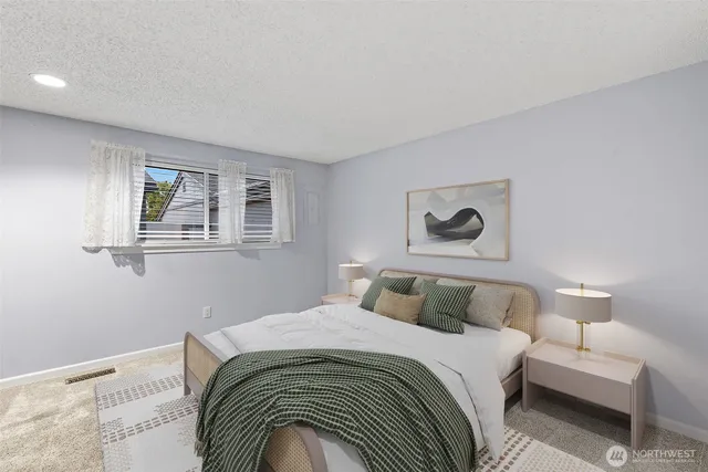 a bedroom with a bed and a painting on the wall