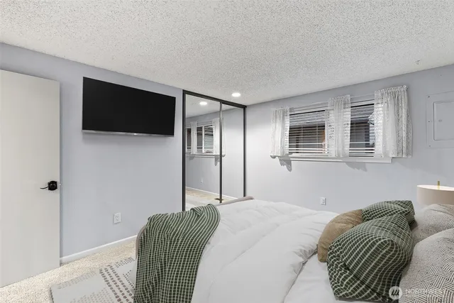 a bedroom with a bed a flat screen tv and wall