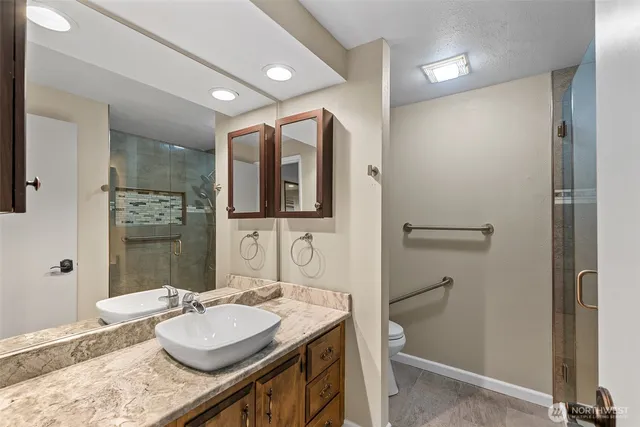 a bathroom with a granite countertop sink and a mirror