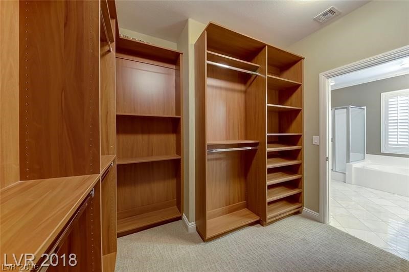3144 Whitfeild Avenue Henderson, NV 89044 - Photo 26 of 55 Custom shelving and hanging space define this well-appointed closet, offering ample storage solutions.
