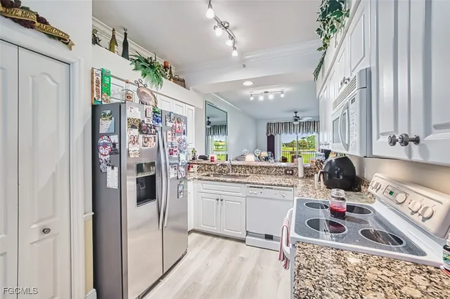 a kitchen with cabinets appliances a sink and a counter top space