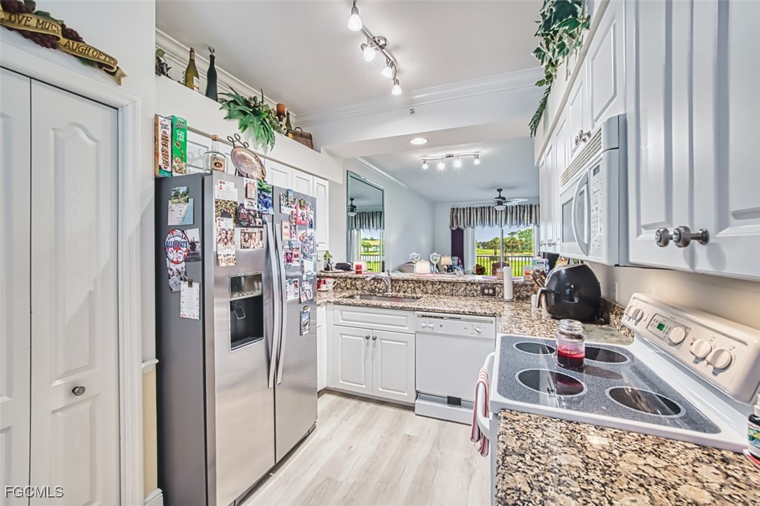 10275 Bismark Palm Way, Unit 1124 Fort Myers, FL 33966 - Photo 11 of 50 a kitchen with stainless steel appliances granite countertop a refrigerator and a stove