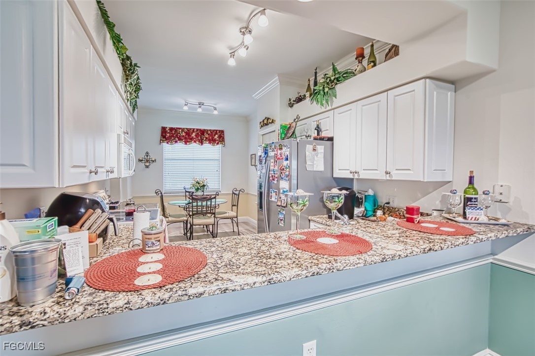 10275 Bismark Palm Way, Unit 1124 Fort Myers, FL 33966 - Photo 14 of 50 a kitchen with kitchen island granite countertop a sink a stove and cabinets