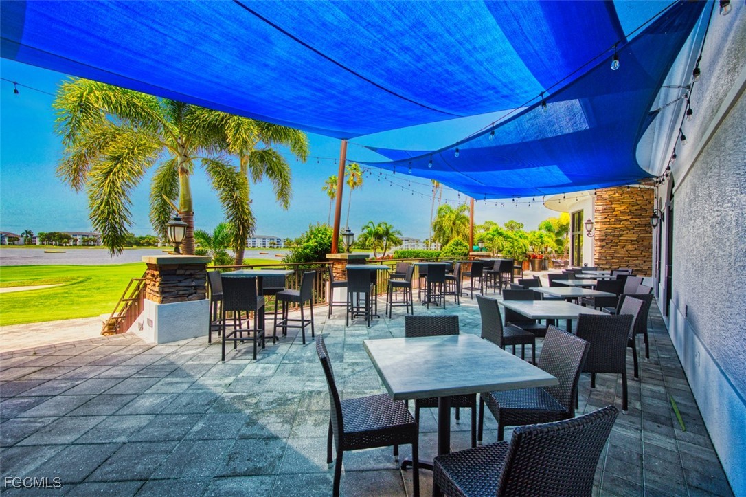 10275 Bismark Palm Way, Unit 1124 Fort Myers, FL 33966 - Photo 45 of 50 a view of a patio with a table chairs and a swimming pool