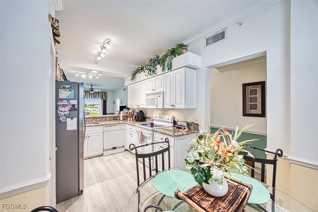 10275 Bismark Palm Way, Unit 1124 Fort Myers, FL 33966 - Photo 9 of 50 a kitchen with a table and chairs in it