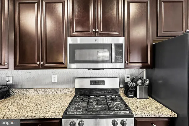 a kitchen with granite countertop stainless steel appliances and wooden cabinets