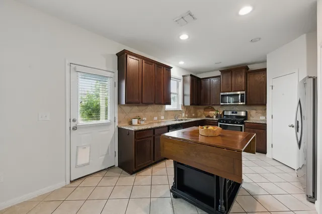 a kitchen with stainless steel appliances granite countertop a sink stove and cabinets