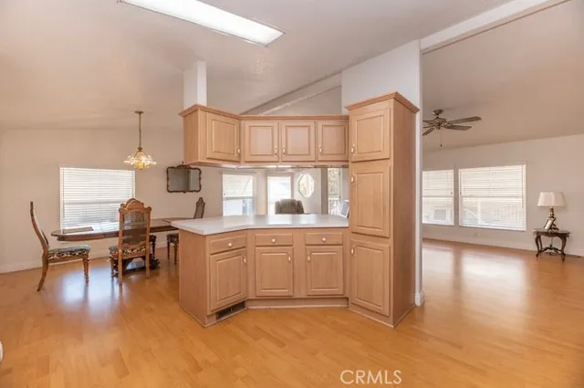 a kitchen with stainless steel appliances granite countertop a refrigerator a stove and white cabinets with wooden floor