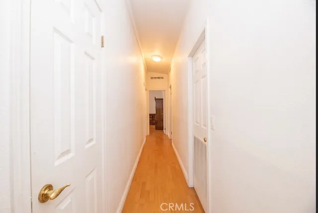 a view of a hallway with wooden floor