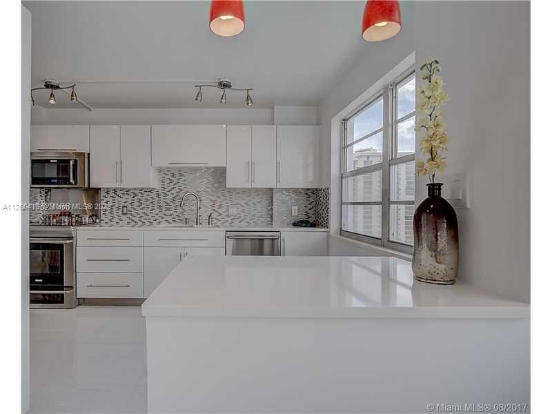 2851 Northeast 183rd Street, Unit 1816E Aventura, FL 33160 - Photo 11 of 29 a kitchen with granite countertop a sink stainless steel appliances and cabinets