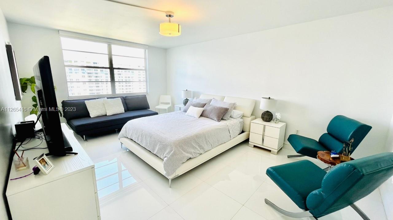 2851 Northeast 183rd Street, Unit 1816E Aventura, FL 33160 - Photo 19 of 29 a bedroom with a bed window and a couch