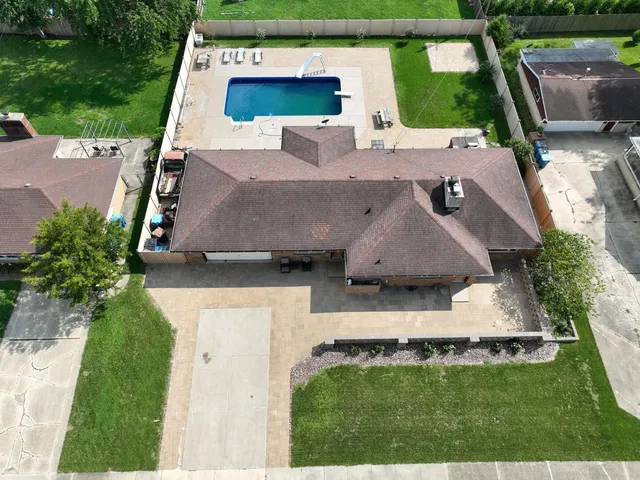 an aerial view of a house with swimming pool garden and patio