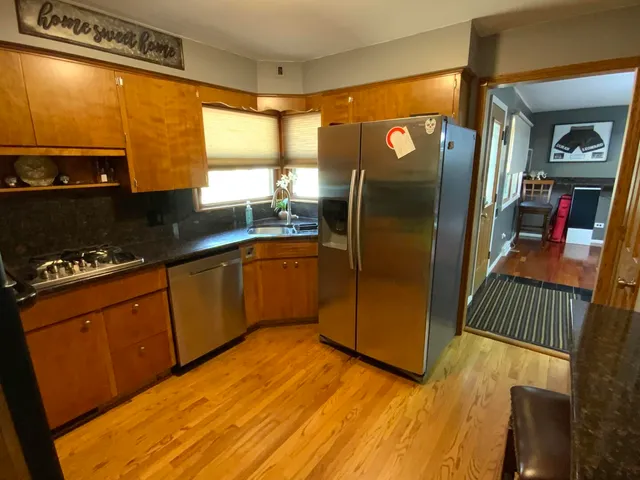 a kitchen with stainless steel appliances granite countertop a sink stove and cabinets