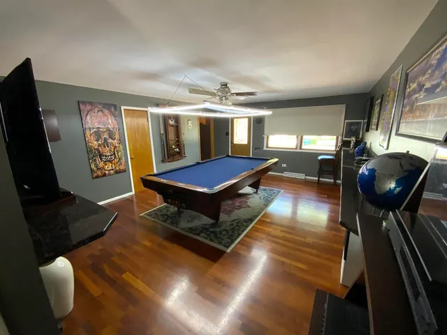 a living room with furniture pool table and flat screen tv