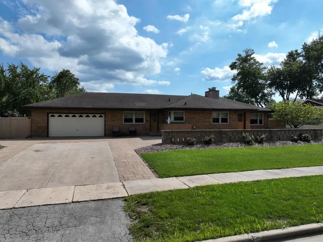 a front view of a house with a garden and trees