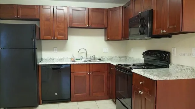 a kitchen with granite countertop stainless steel appliances a stove a sink and a microwave
