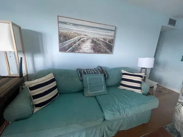 a living room with furniture and a painting on the wall