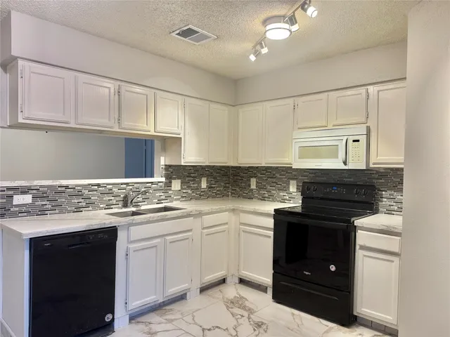 a kitchen with a sink stove and cabinets