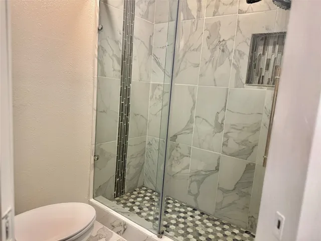 a bathroom with a toilet and shower