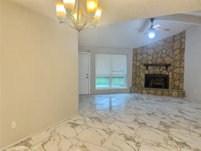 a view of empty room with fireplace and fan