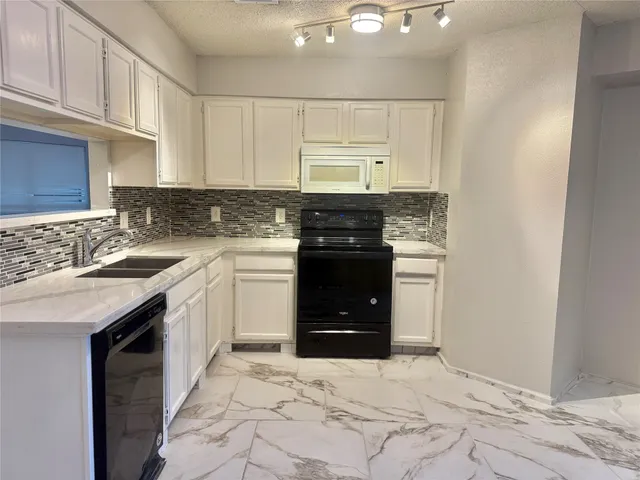 a kitchen with a sink stove and cabinets