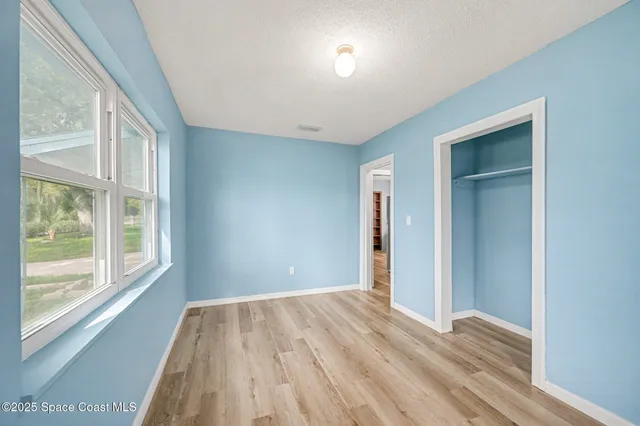 a view of room with window and wooden floor