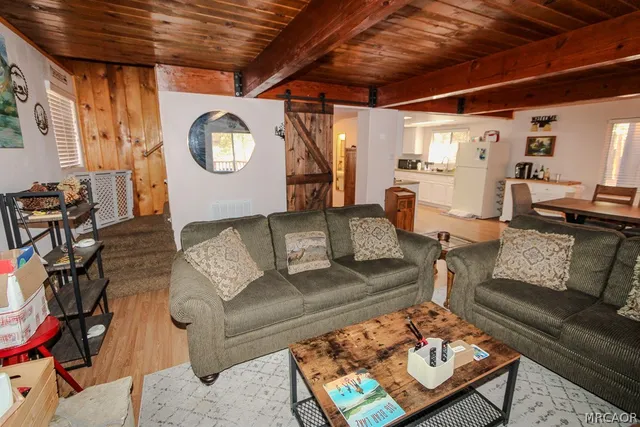 a living room with furniture a clock on wall and a table