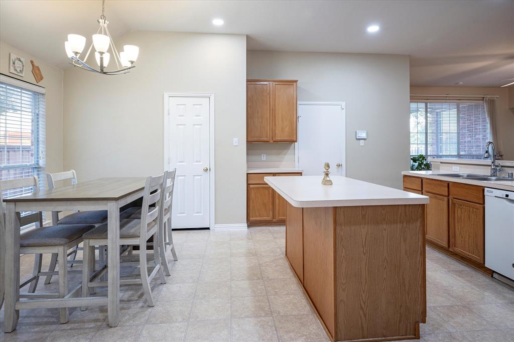 7906 Munich Drive Rowlett, TX 75088 - Photo 12 of 31 a kitchen with a table chairs sink and cabinets