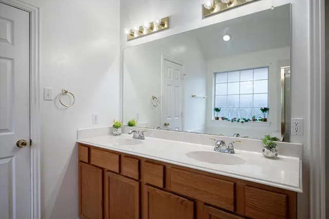 a bathroom with a sink double vanity granite and a mirror