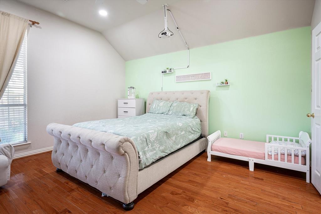 7906 Munich Drive Rowlett, TX 75088 - Photo 8 of 31 a bedroom with a bed and a night stand