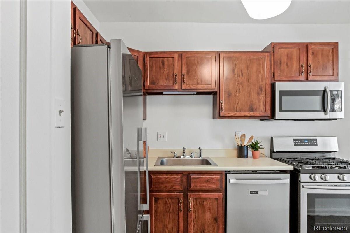 1575 Fillmore Street, Unit 6 Denver, CO 80206 - Photo 11 of 15 a kitchen with stainless steel appliances granite countertop a refrigerator and a stove top oven