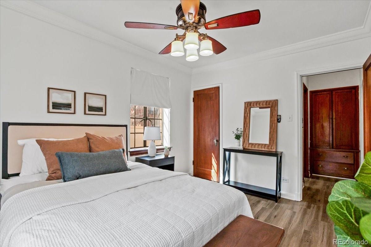 1575 Fillmore Street, Unit 6 Denver, CO 80206 - Photo 14 of 15 a bedroom with a bed a chandelier and dresser