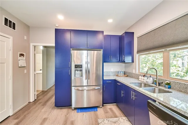 a kitchen with a refrigerator sink and cabinets