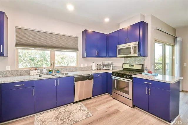 a kitchen with stainless steel appliances granite countertop wooden cabinets stove top oven a sink and dishwasher next to a window