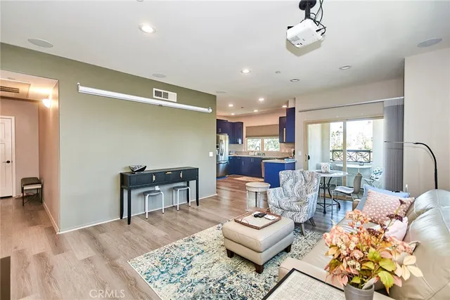 a living room with furniture and a dining table with kitchen view