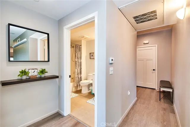 a view of a hallway and closet with wooden floor