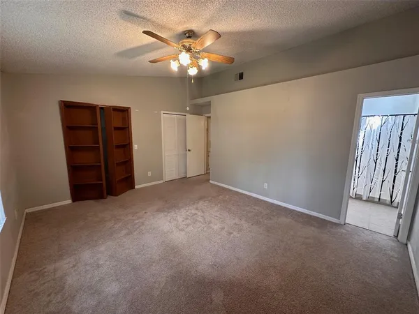an empty room with closet and fan