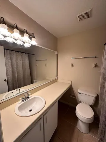 a bathroom with a sink vanity and toilet