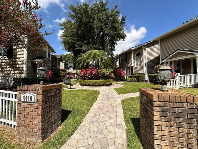 a front view of a house with a yard garden and outdoor seating