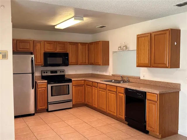 a kitchen with stainless steel appliances granite countertop a sink and a stove