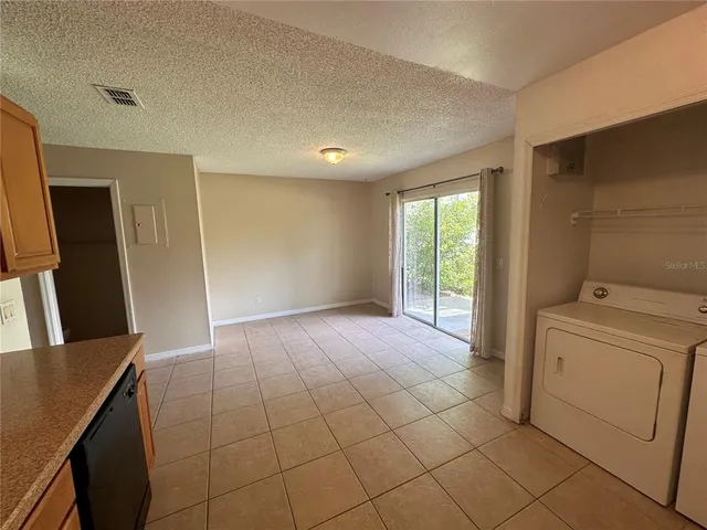 a view of a kitchen with fridge and wooden floor