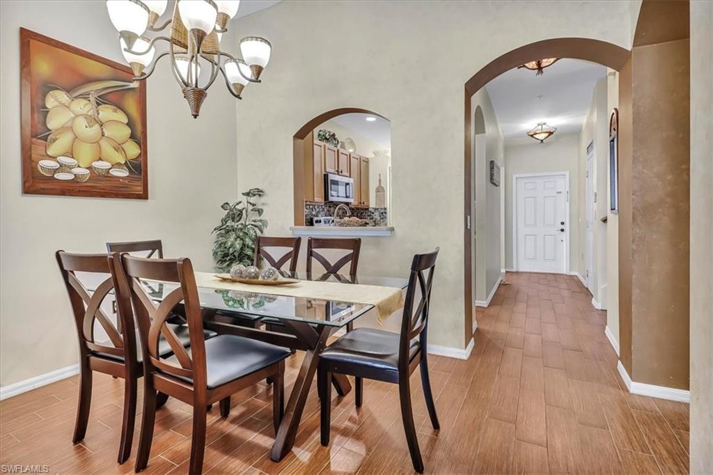 14130 Winchester Court, Unit 1503 Naples, FL 34114 - Photo 5 of 39 Dining area featuring a notable chandelier and light wood-type flooring