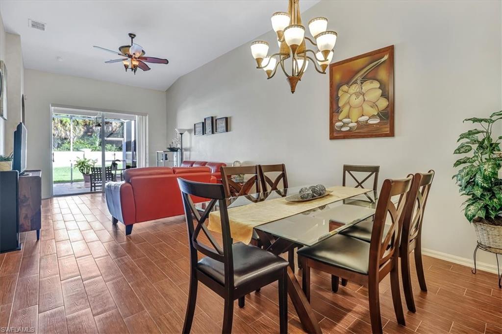 14130 Winchester Court, Unit 1503 Naples, FL 34114 - Photo 6 of 39 Dining area with wood-type flooring, vaulted ceiling, and ceiling fan with notable chandelier