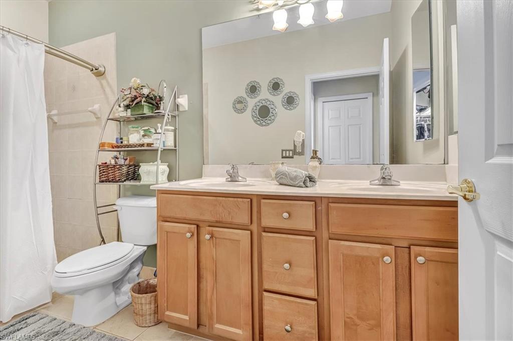 14130 Winchester Court, Unit 1503 Naples, FL 34114 - Photo 10 of 39 Bathroom featuring tile flooring, dual vanity, and toilet