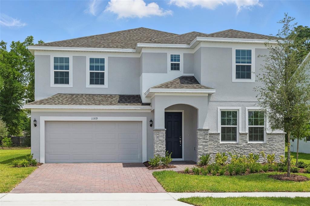 a front view of a house with a garden and plants